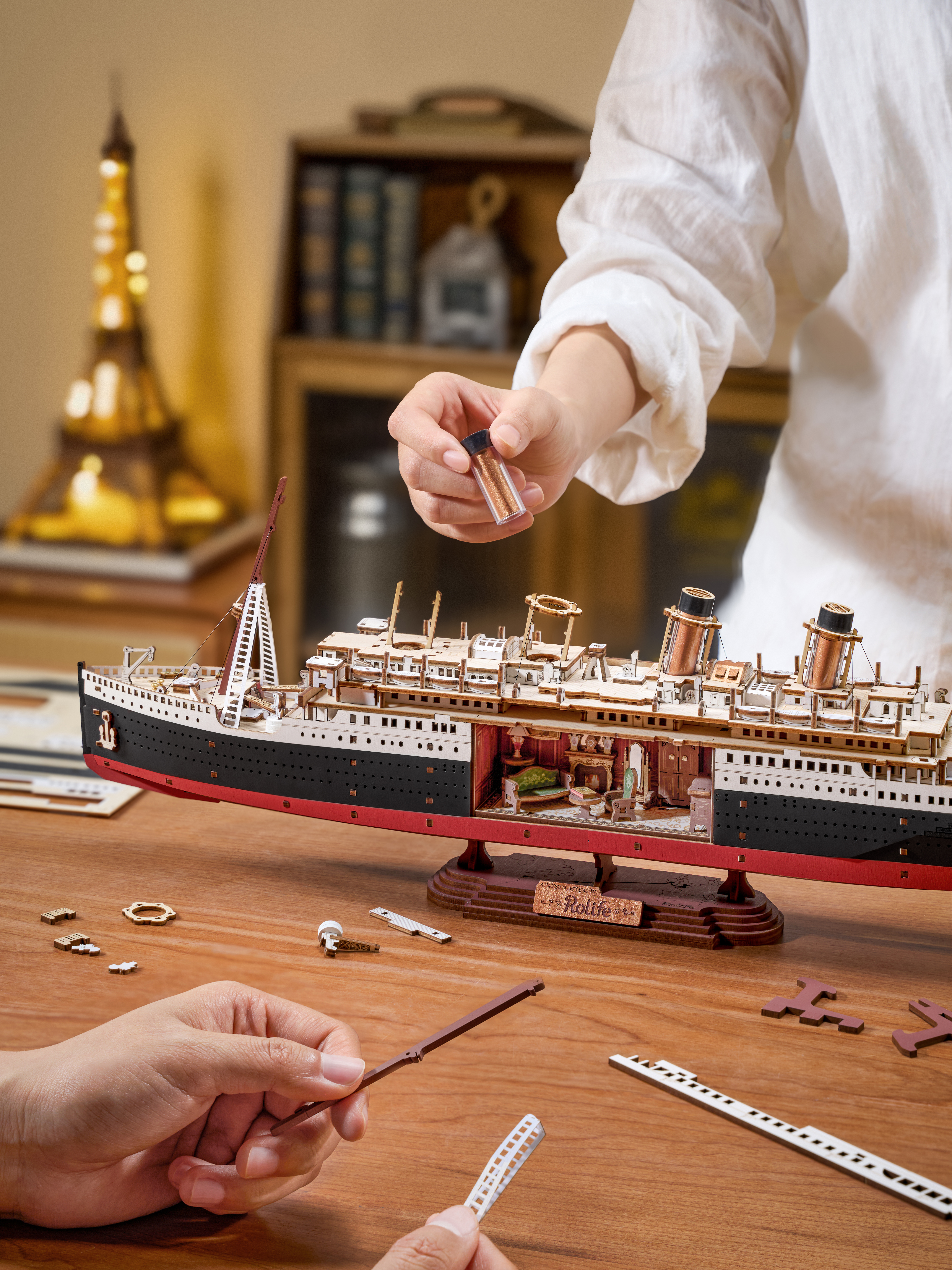 Rolife Eternal Atlantic Voyager wooden 3D puzzle ship model with LED lights and detailed deck design displayed on a desk